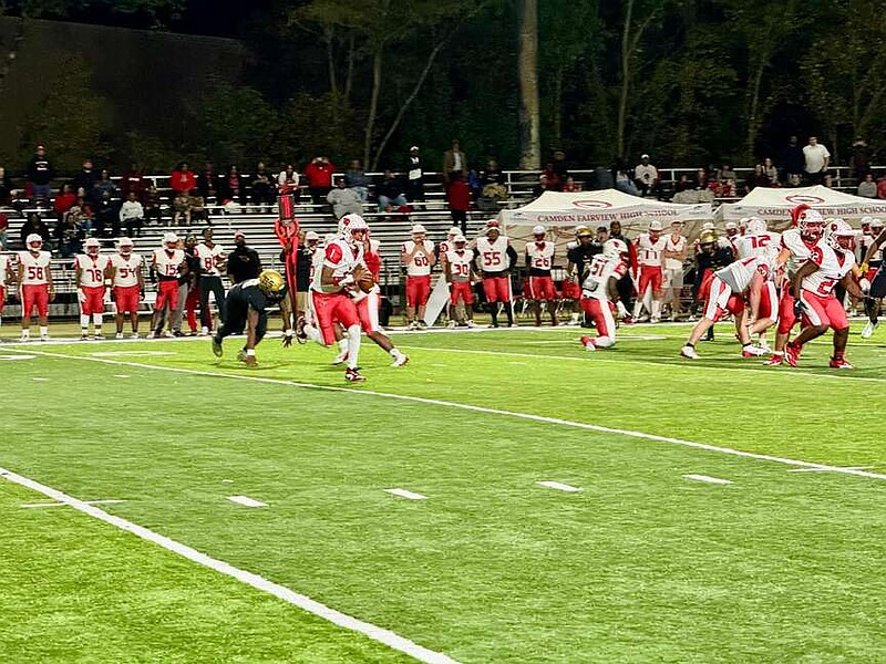 Camden Fairview quarterback Darre'll Atkins Jr. rolls out to throw a pass against Hot Springs Friday night at Joe Reese Stadium. The Cardinals beat the Trojans 34-6. (The Sentinel-Record/Bryan Rice)