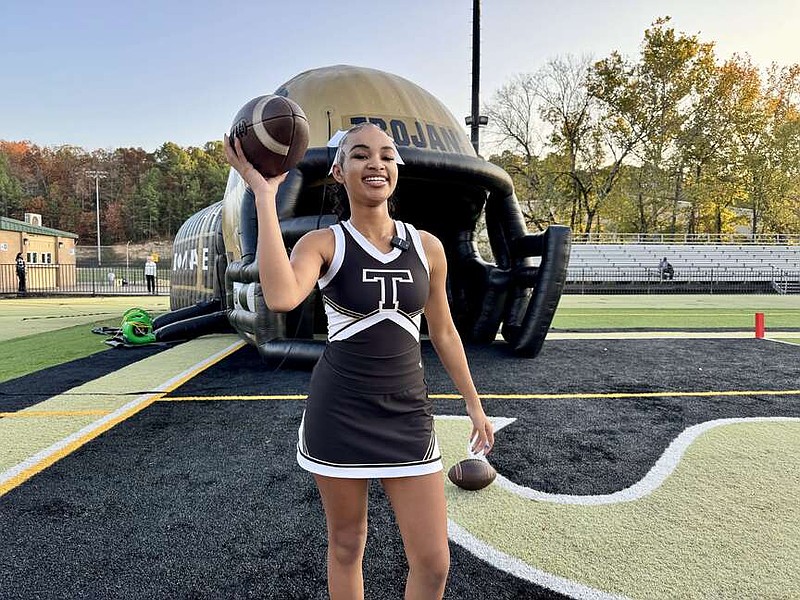 Hot Springs senior cheerleader Ta'Laila Cunningham holds a football before the Trojans' home game against Camden Fairview last week at Joe Reese Stadium. (The Sentinel-Record/Bryan Rice)