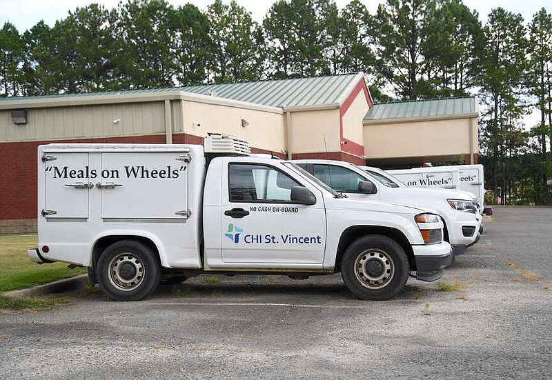 Meals on Wheels delivery trucks are shown parked outside the CHI St. Vincent McAuley Senior Center off Highway 7 north in August. (The Sentinel-Record/Donald Cross/File)