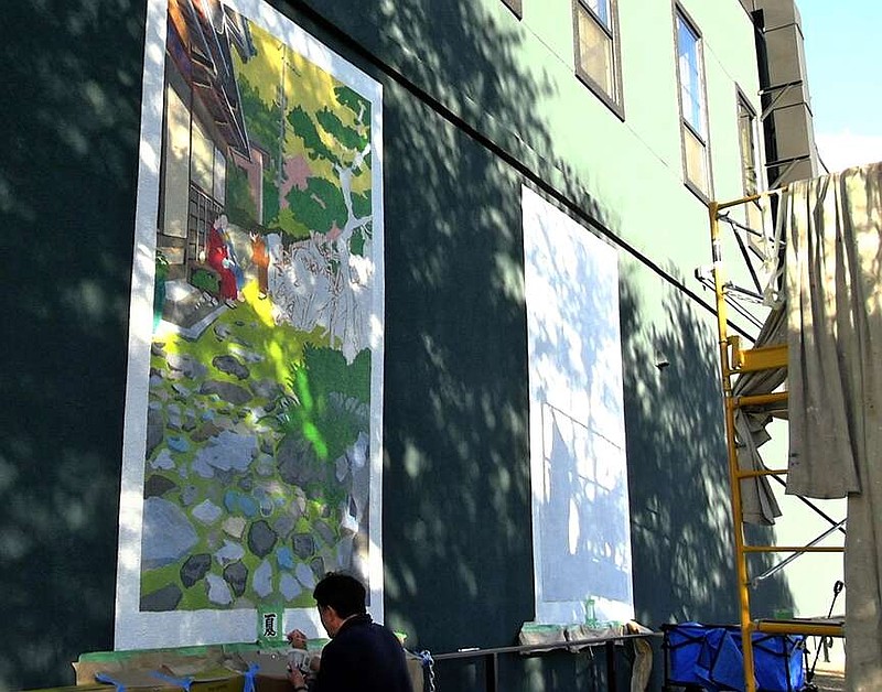 Kohei Kashiwaba paints the Japanese character for summer on Pepe Gaka's mural depicting the four seasons in Hanamaki, Japan. (The Sentinel-Record/Thomas Buckman)