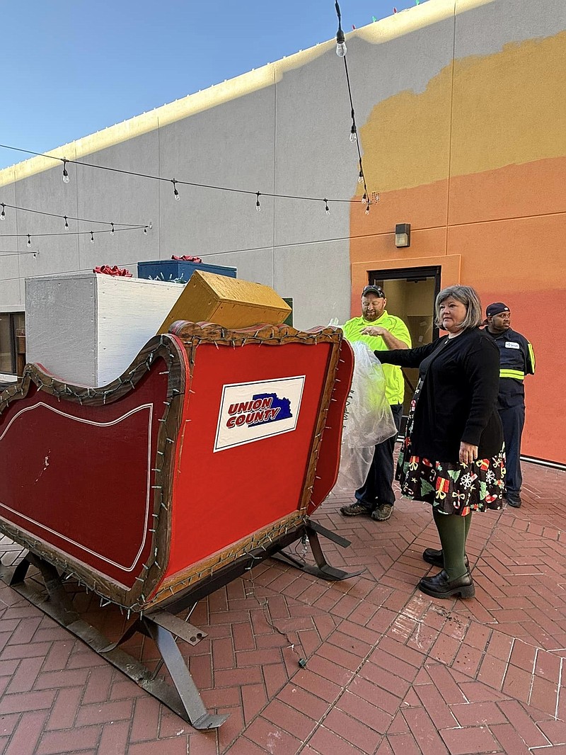 Karen Hicks of the El Dorado Union County Chamber of Commerce inspects Santa's sleigh, brought from the North Pole. (Courtesy photo)