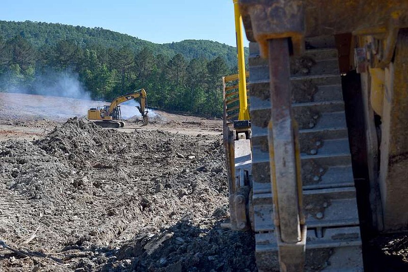 A Caterpillar 320F excavator, left, is shown at work on the Garland County Landfill in May. (The Sentinel-Record/Donald Cross/File)