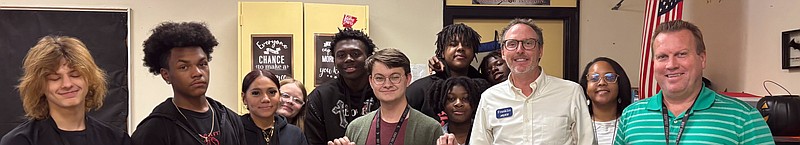 Hot Springs World Class High School English teacher Chad Hall, center, stands with Arvest Community Bank President Franklin Bass, center right, along with students and teachers in Hall's classroom. (Submitted photo)