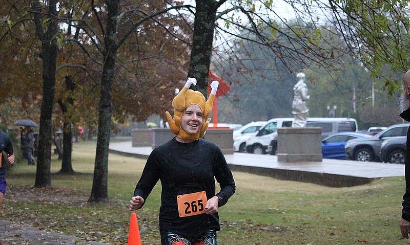 A runner crosses the finish line at the Ken Freeman Huff, Puff, then Stuff 5K Turkey Trot in 2022. (The Sentinel-Record/File)