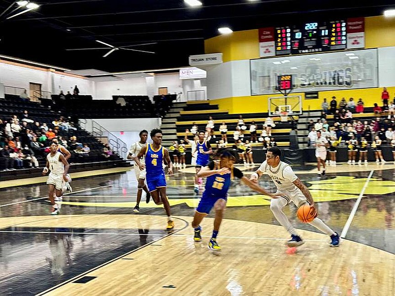 North Little Rock Charging Wildcats guard Elijah Bryant (14), left, defends Hot Springs senior Jai'Chaunn Hayes (3), right, in Trojan Arena Friday during the Hot Springs Invitational. (The Sentinel-Record/Bryan Rice)