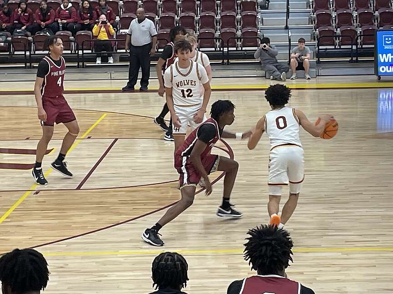 Lake Hamilton's Victor Easter (0) dribbles out front while Eli McCain (12) prepares to set a screen Tuesday night during the Wolves' home matchup against Pine Bluff. (The Sentinel-Record/Braden Sarver)