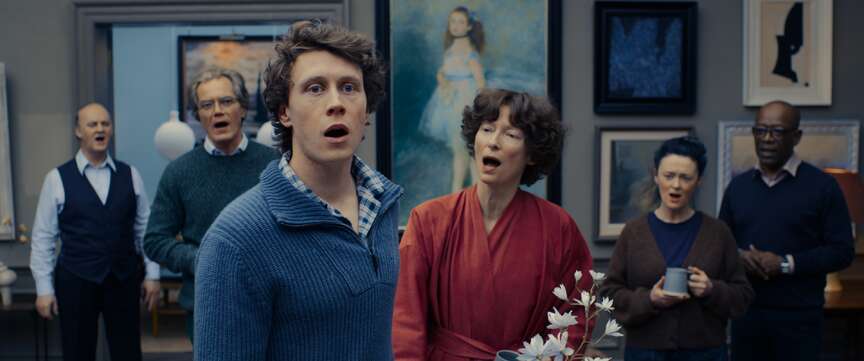From left, Tim McInnerny, Michael Shannon, George MacKay, Tilda Swinton, Bronagh Gallagher and Lennie James sing their troubles in “The End.” MUST CREDIT: Neon