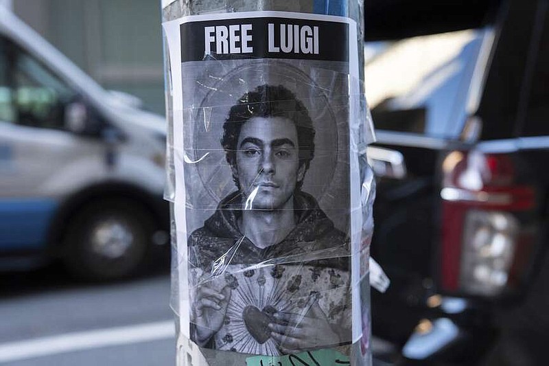 A poster depicting Luigi Mangione hangs outside the New York Hilton Midtown hotel Thursday, Dec. 12, 2024, in New York. (AP Photo/Julia Demaree Nikhinson)