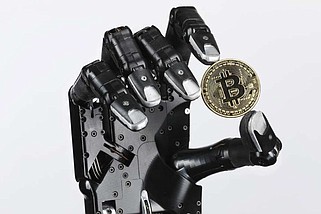 The Shadow Dexterous robotic hand holds a coin representing Bitcoin cryptocurrency in an arranged photograph in London on Feb. 14, 2018. (MUST CREDIT: Luke MacGregor/Bloomberg)