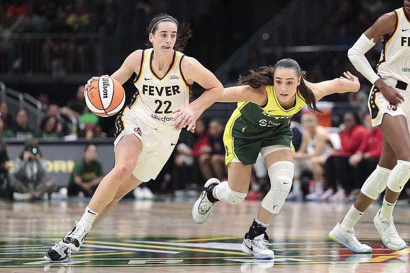 FILE - Indiana Fever guard Caitlin Clark (22) drives as Seattle Storm guard Nika Muhl defends during the second half of a WNBA basketball game, Wednesday, May 22, 2024, in Seattle. (AP Photo/Jason Redmond, File)