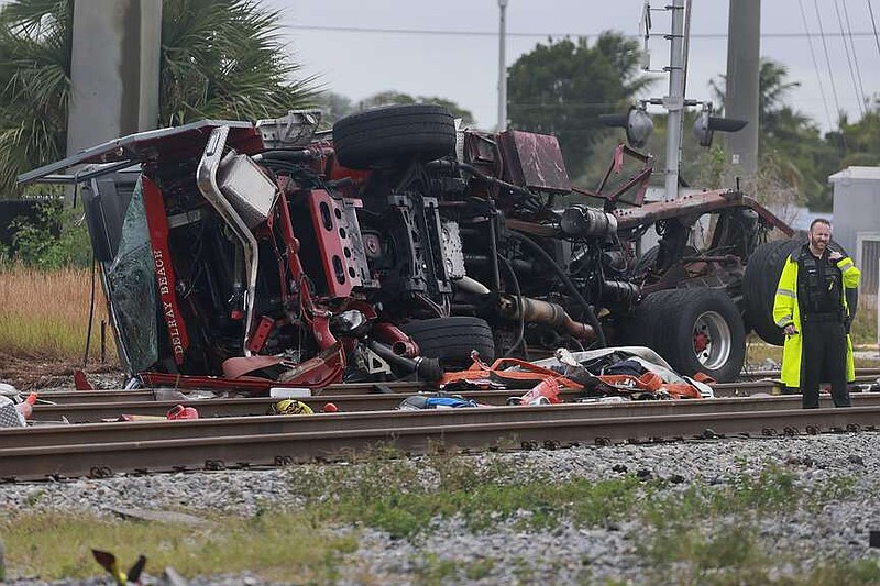 A damaged fire truck is on its side after colliding with a train in downtown Delray Beach, Fla., Saturday, Dec. 28, 2024. (Mike Stocker/South Florida Sun-Sentinel via AP)