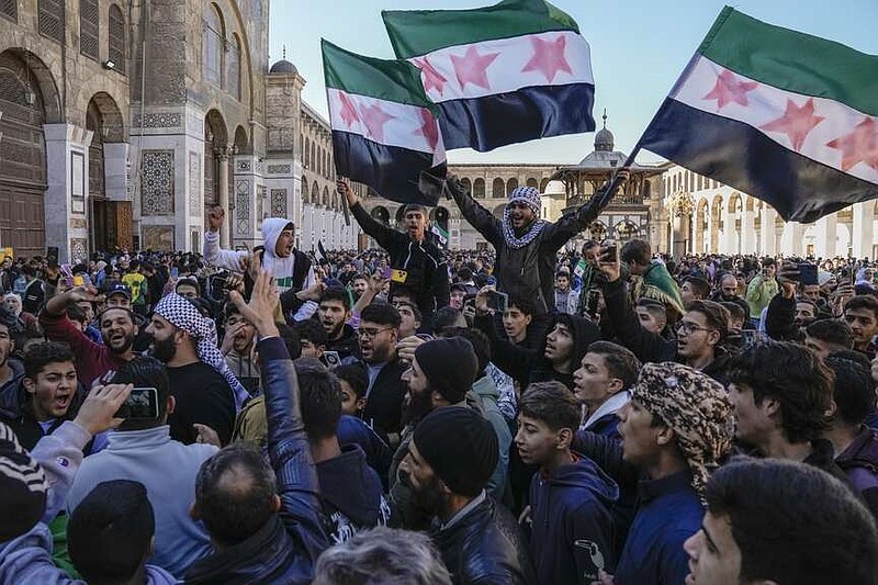 FILE - People chant slogans and wave the new Syrian flag as they gather for Friday prayers at the Umayyad mosque in Damascus, Syria, on Dec. 13, 2024. (AP Photo/Leo Correa, File)