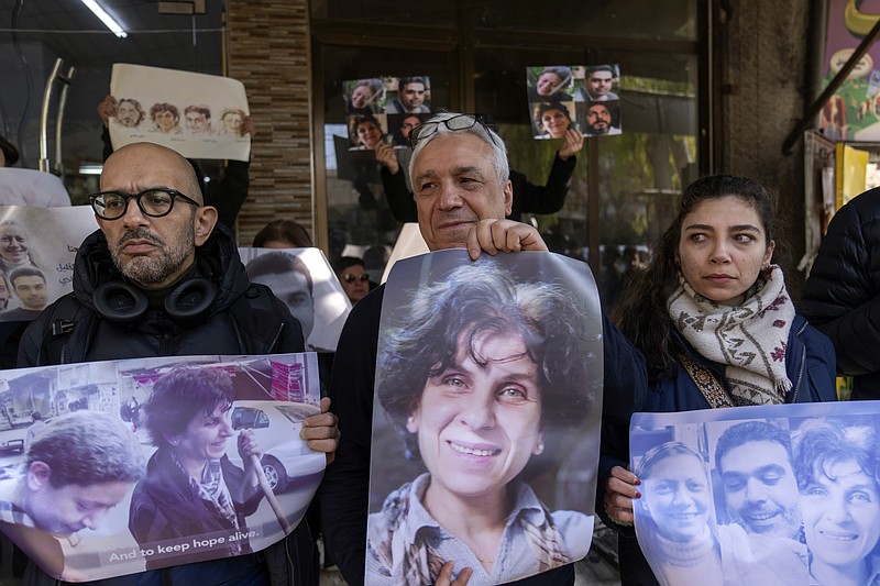 Relatives take part in a protest demanding the whereabouts of four activists who disappeared during the war between opposition groups and former President Bashar Assad's forces, in Douma, Syria, Wednesday, Jan. 1, 2025. (AP Photo/Mosa'ab Elshamy)