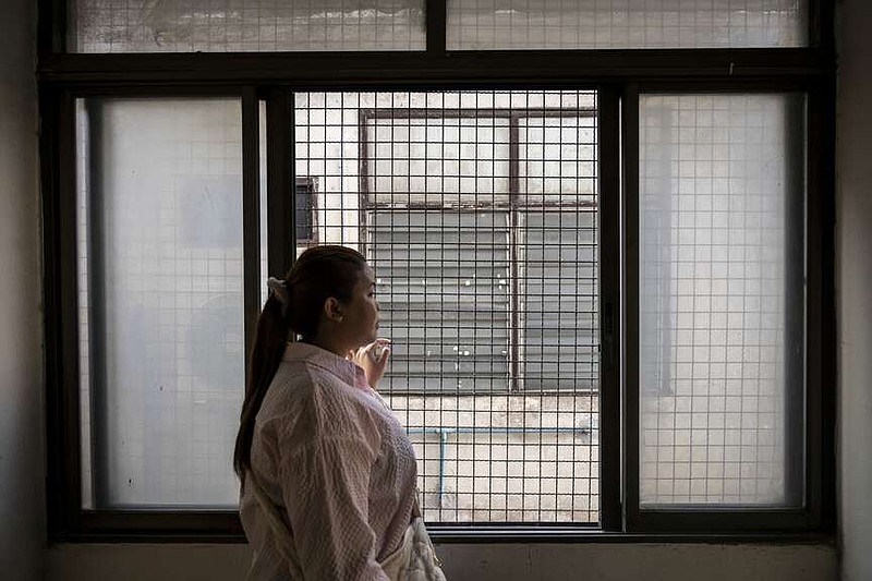 Sun Sophea, 30, a Cambodian opposition activist, was smuggled through a corridor to Thailand. She gazes out a window April 29 from a building in Bangkok that houses a small group of refugees. (Sirachai Arunrugstichai for The Washington Post)