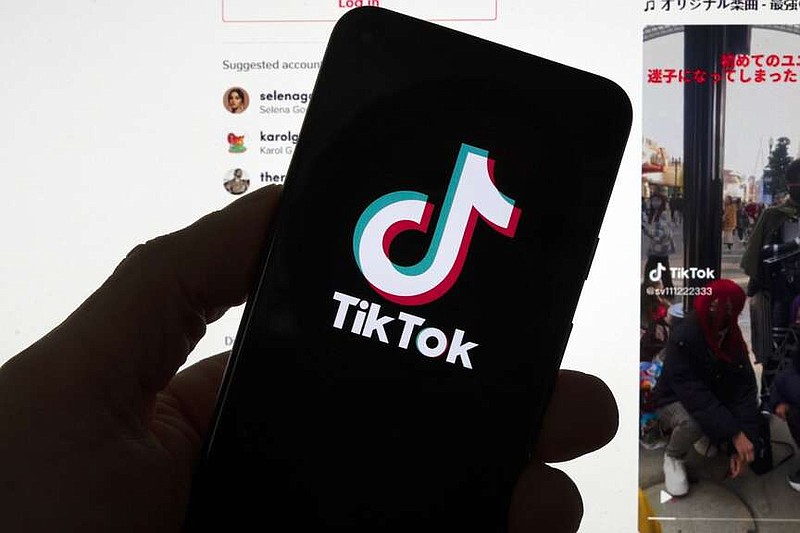 The TikTok logo is displayed on a mobile phone in front of a computer screen which displays a TikTok home page, Saturday, March 18, 2023, in Boston. (AP Photo/Michael Dwyer, File)