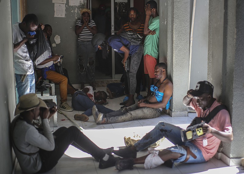 Journalists sit wounded after being shot by armed gangs at the General Hospital in Port-au-Prince, Haiti, Tuesday, Dec. 24, 2024. (AP Photo/Jean Feguens Regala)