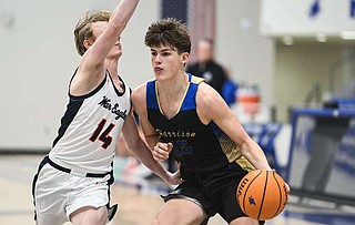 Harrison Ryder Scribner (15) drives past Rogers Heritage guard Maximus Howard (14), Friday, December 13, 2024 during the Arvest HoopFest boys basketball game at Mountie Arena at Rogers High School in Rogers. Visit nwaonline.com/photo for today's photo gallery.

(NWA Democrat-Gazette/Charlie Kaijo)