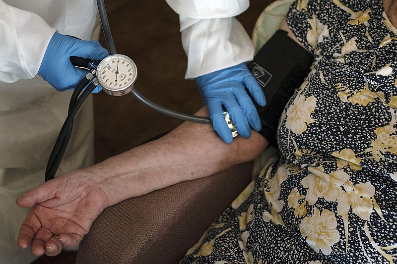 FILE - A doctor checks the blood pressure of A 94-year-old woman in Sant Sadurn&#xed; d'Anoia, Catalonia region, Spain, Friday, July 31, 2020. (AP Photo/Felipe Dana, File)