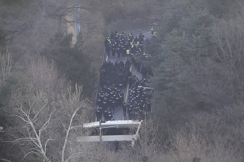 Investigators from the state anti-corruption agency and police officers make their way to the residence of impeached President Yoon Suk Yeol to execute a warrant to detain Yoon in Seoul, South Korea, Wednesday, Jan. 15, 2025. (AP Photo/Ahn Young-joon)