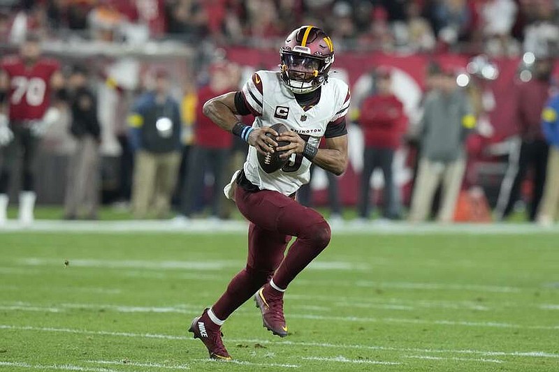 Washington Commanders quarterback Jayden Daniels (5) scrambles out of the pocket against the Tampa Bay Buccaneers during the first half of Sunday's NFL wild-card playoff game in Tampa, Fla. (AP Photo/Chris O'Meara)