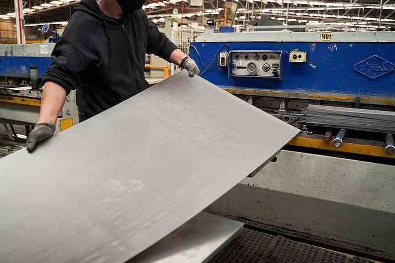 A worker feeds sheet aluminum into a machine at an auto parts manufacturer in San Luis Potosi, Mexico. MUST CREDIT: Mauricio Palos/Bloomberg