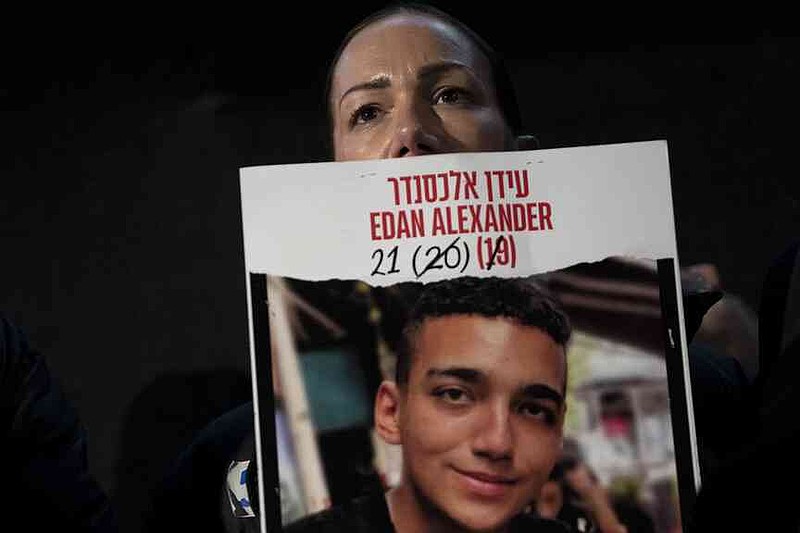 Yael Alexander holds a poster of her son Edan, who was taken hostage by Hamas on October 7, 2023, while a weekly rally for families of hostages in the Gaza Strip and their followers in Tel Aviv, Israel, Saturday, February 22nd, (AP Photo/Maya Alluzzo)).