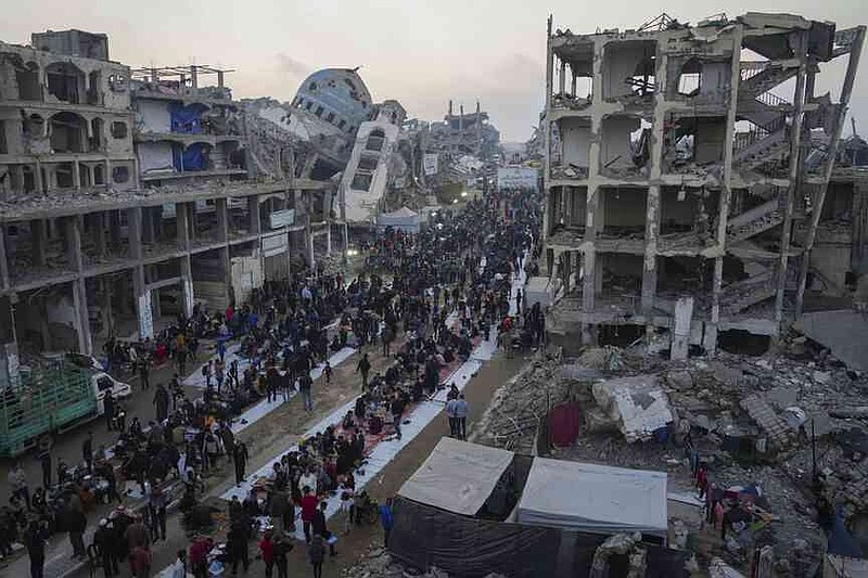 Surrounded by destroyed houses and buildings, the Palestinians gather for Iftar, the fast food during Ramadan in Beit Lahia, on Saturday, March 15, 2025, (AP Photo/Jehad Alshrafi), on Saturday, March 15, 2025).