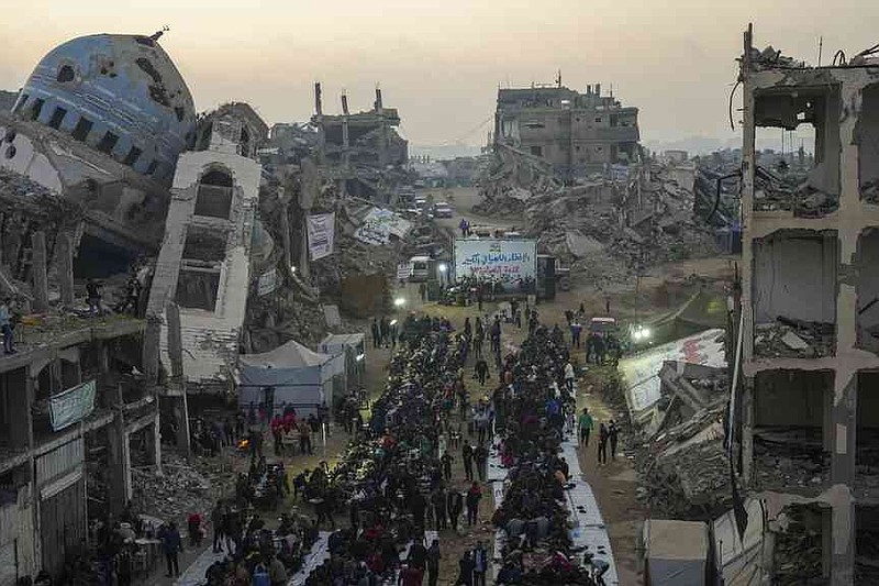 Surrounded by destroyed houses and buildings, the Palestinians gather for Iftar, the fast food during Ramadan in Beit Lahia, on Saturday, March 15, 2025, (AP Photo/Jehad Alshrafi), on Saturday, March 15, 2025).