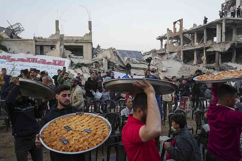 Traditional sweets are served at the tables, as the residents prepare themselves on Isftar, the fast food, during the Ramadan in the war -coated Beit Lahia, the Northern Gaza Strip, on Saturday, March 15, 2025. (AP Photo/Jehad Alshrafi)