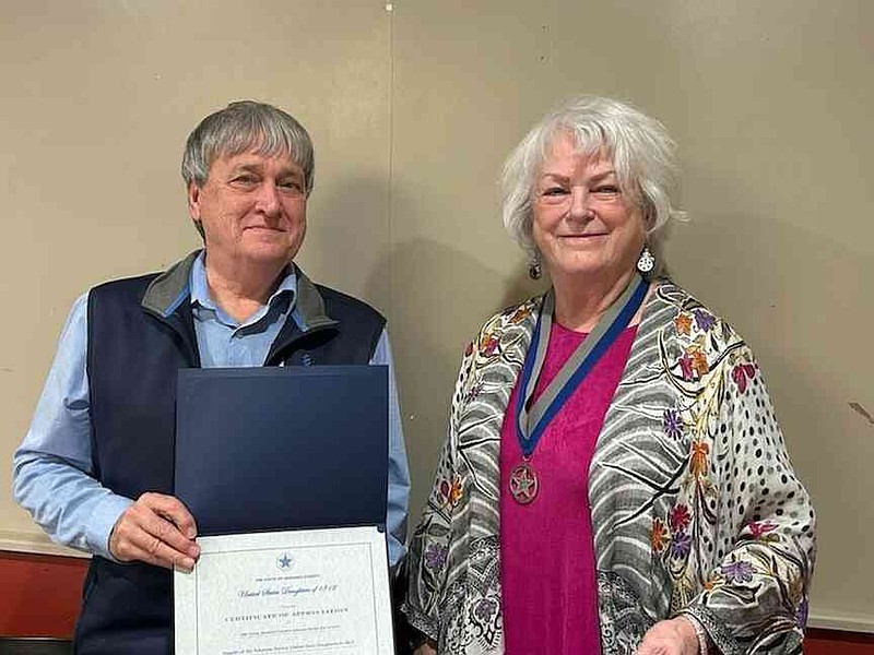 General Society War of 1812 State Treasurer/Secretary John Tatum, left, accepts an award from USD 1812 State President Sheila Beatty. (Special to The Commercial)