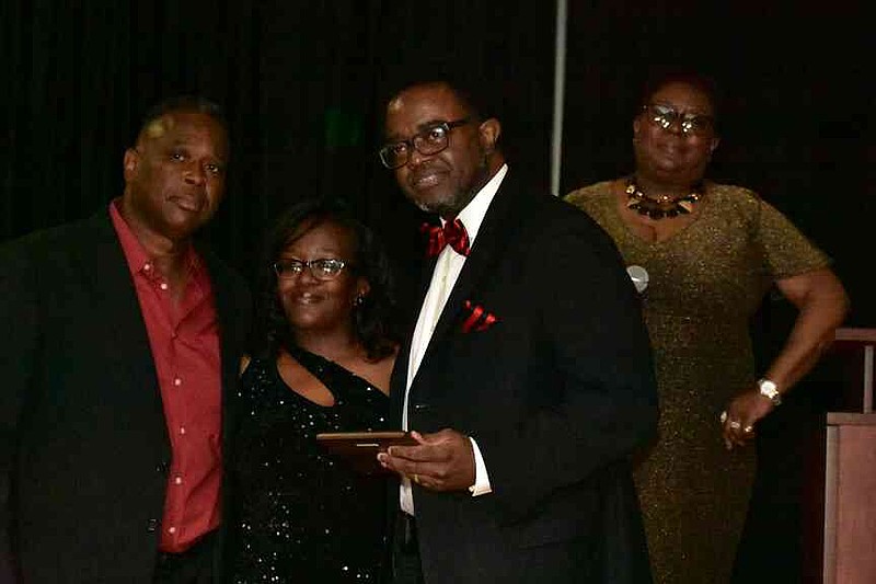 Kevin Crumpton Sr., center right, is pictured with his Be Great Award along with Ben Redix Sr. and Shaneisha Robinson, the parents of Benjamen Redix, and Flo Rambert, Benjamen's grandmother, at the second annual Benjamen Redix Project Gala. (Pine Bluff Commercial/I.C. Murrell)