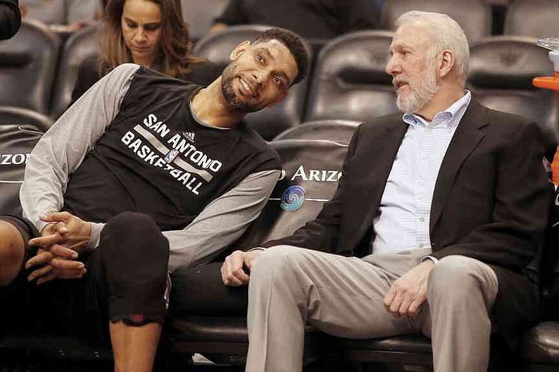 File - In this February 28, 2015, FileFoto, San Antonio Spurs Forward Tim Duncan, left, and head coach Gregg Popovich Chat on the bench during the first quarter of an NBA basketball game against the Phoenix Sun in Phoenix. (AP Photo/Rick Scuteri, File)