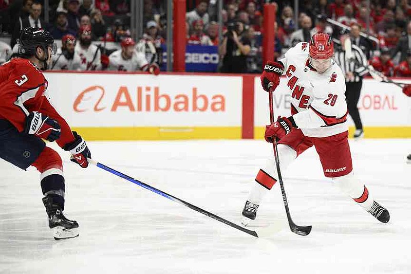 The Carolina Hurricanes Center Sebastian Aho (20) shoots in the second phase of an NHL hockey game, Thursday, April 10, 2025, in Washington against Washington Capitals, Matt Roy (3). (AP Photo/Nick Wass)