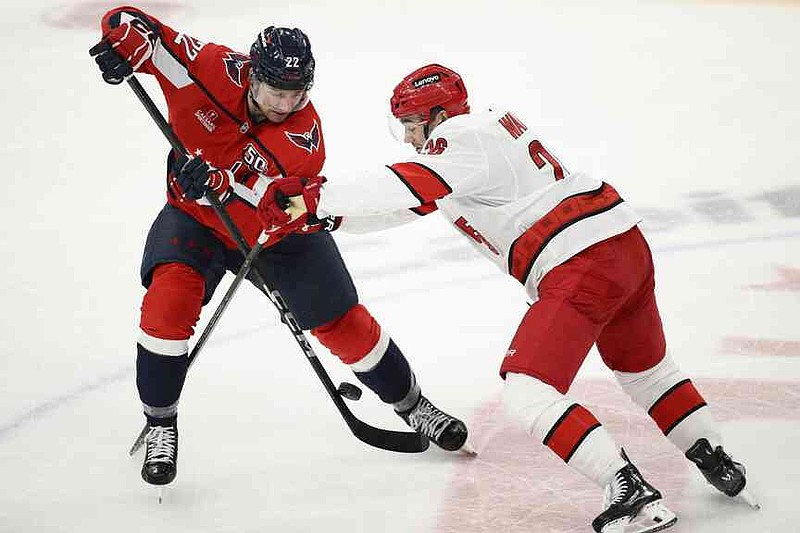Washington Capitals Right Wing Brandon Duhaime (22) battles around the puck against Carolina Hurrican defender Sean Walker, right, during the third period of an NHL hockey game, Thursday, April 10, 2025, in Washington. (AP Photo/Nick Wass)