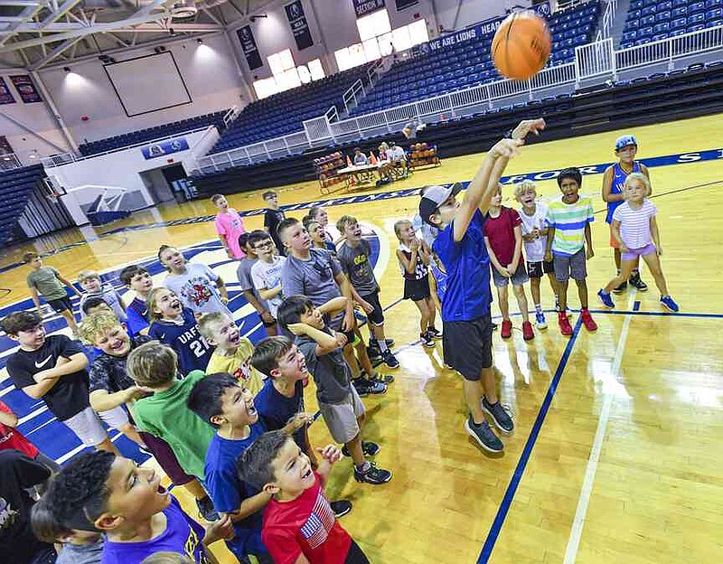 Benjamin Weaver (center) shoots a free throw as fellow campers cheer during the 2024 youth basketball camp inside the Stubblefield Center on the UAFS campus in Fort Smith.  Visit rivervalleydemocratgazette.com/photo for today's photo gallery. (File Photo/River Valley Democrat-Gazette-Hank Layton)