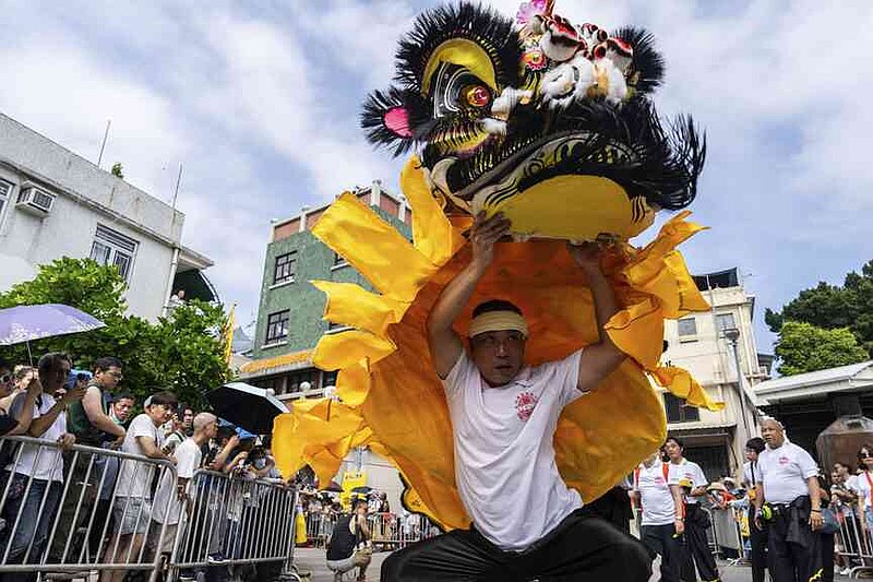 A participant performs lion dance in the Piu Sik Parade at the Bun Festival in Cheung Chau Island in Hong Kong, Monday, May 5, 2025. (AP Photo/Chan Long Hei)