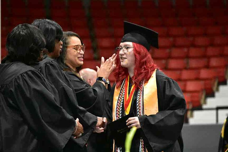 Watson Chapel School District board members (from left) Goldie Whitaker, Connie Compton and Rosemary White congratulate Ashley Trammell upon her receiving a diploma. (Pine Bluff Commercial/I.C. Murrell)