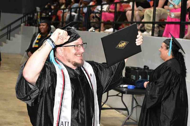 A graduate flexes his muscles after receiving his award. (Pine Bluff Commercial/I.C. Murrell)
