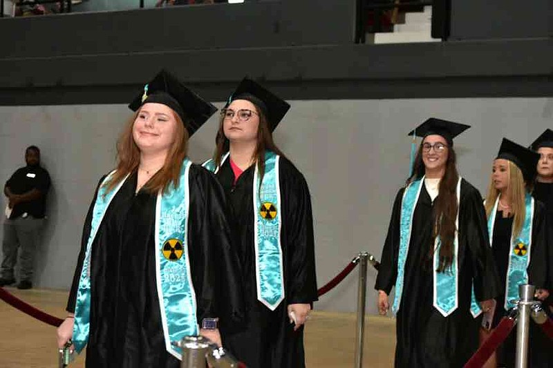 Rachel Ball (left) and Megan Castillo lead their fellow radiologic technology graduates during the processional. (Pine Bluff Commercial/I.C. Murrell)