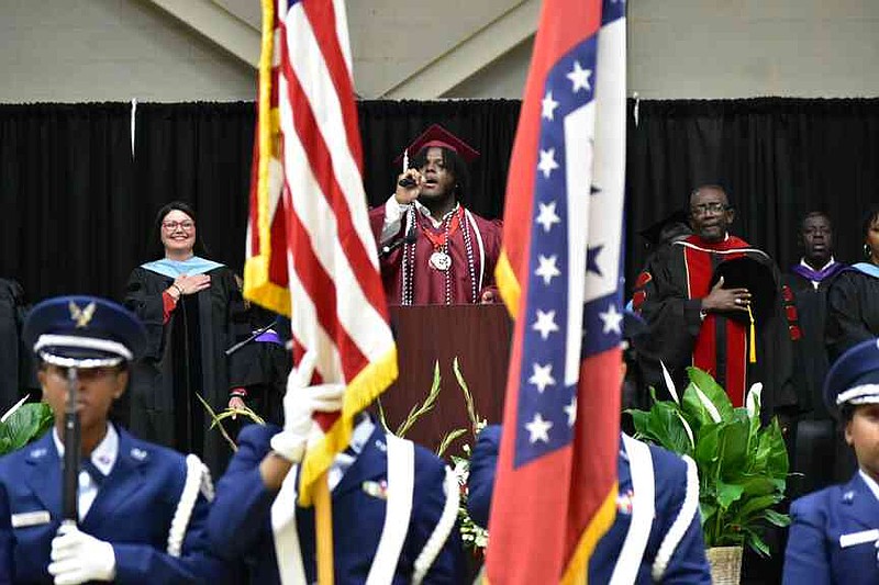 Danny Johnson sings a rousing rendition of the national anthem as Pine Bluff School District Superintendent Jennifer Barbaree and Pine Bluff High School Principal Ronald Laurent take it in. (Pine Bluff Commercial/I.C. Murrell)