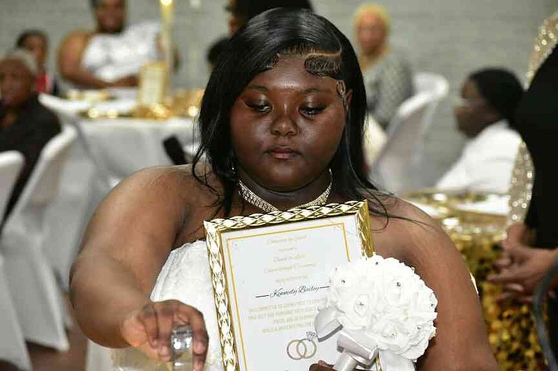 Kennedy Bailey pours unity sand into a vase upon making her vow for self-preservation. (Pine Bluff Commercial/I.C. Murrell)