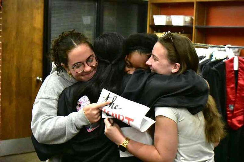 Recent White Hall High graduates Bree O'Keefe (left), Kajah Hodge and Hannah Owings embrace Leslie Mitchell following an early morning ceremony. (Pine Bluff Commercial/I.C. Murrell)