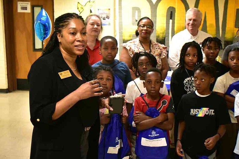 Watson Chapel School District assistant superintendent Aleta Posey records a video with Simmons Bank representatives and members of Kenya Hudson's third-grade class at Coleman Elementary. Hudson is second from right in the back row. (Pine Bluff Commercial/I.C. Murrell)