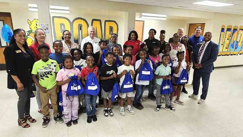 Simmons Bank representatives and Watson Chapel School District officials pose with Kenya Hudson's third-grade class for a group photo inside Coleman Elementary. (Pine Bluff Commercial/I.C. Murrell)