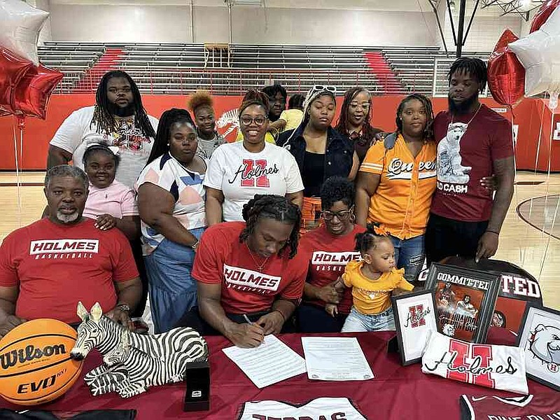 Deriyon Graydon, seated center, signs his letter of intent with Holmes Community College surrounded by family. (Special to The Commercial/Pine Bluff School District)