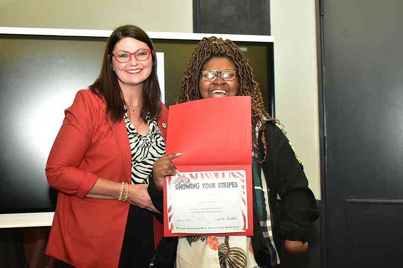Pine Bluff School District Superintendent Jennifer Barbaree presents a Showing Your Stripes certificate to Cierra Williams