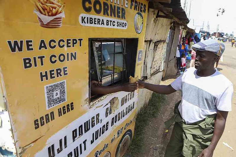 Kevin Gundo buys chips at a shop that accepts bitcoin payments at Kibera Slums in Nairobi, Kenya, Sunday, May 4, 2025. (AP Photo/Andrew Kasuku)