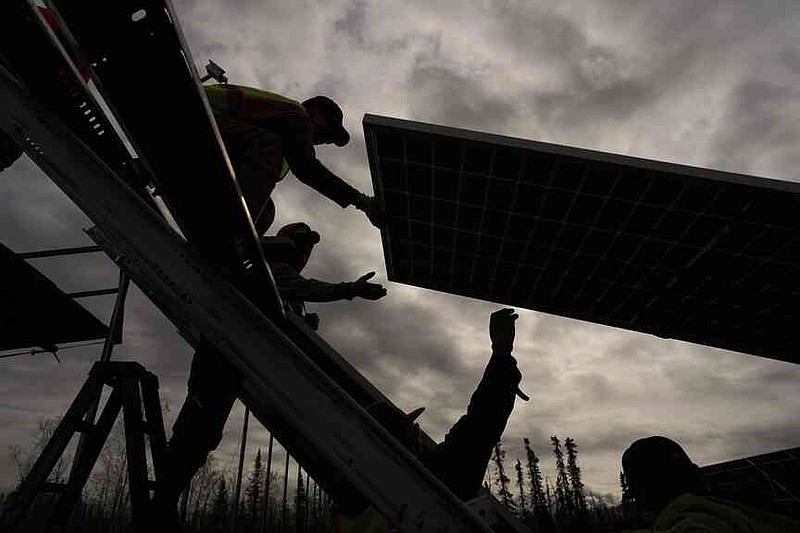 Workers install panels at a solar project Wednesday, May 21, 2025, in Galena, Alaska. (AP Photo/John Locher)