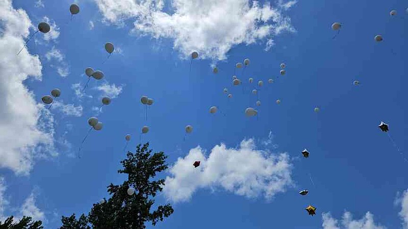 Balloons, many of them with messages honoring victims of a June 21, 2024, mass shooting in Fordyce, are released from a ballpark in the town. (Pine Bluff Commercial/I.C. Murrell)
