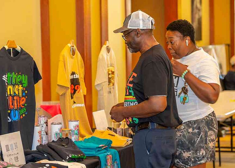 Father and daughter, Darnell and Amber Bledsoe, shop with vendors during Stuttgart's Juneteenth Celebration at the Grand Prairie Center. (Pine Bluff Commercial/Eplunus Colvin)